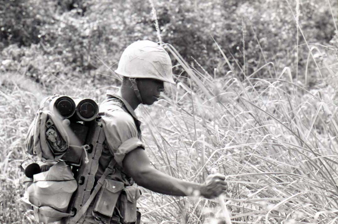 American soldier standing in tall grass, 1967