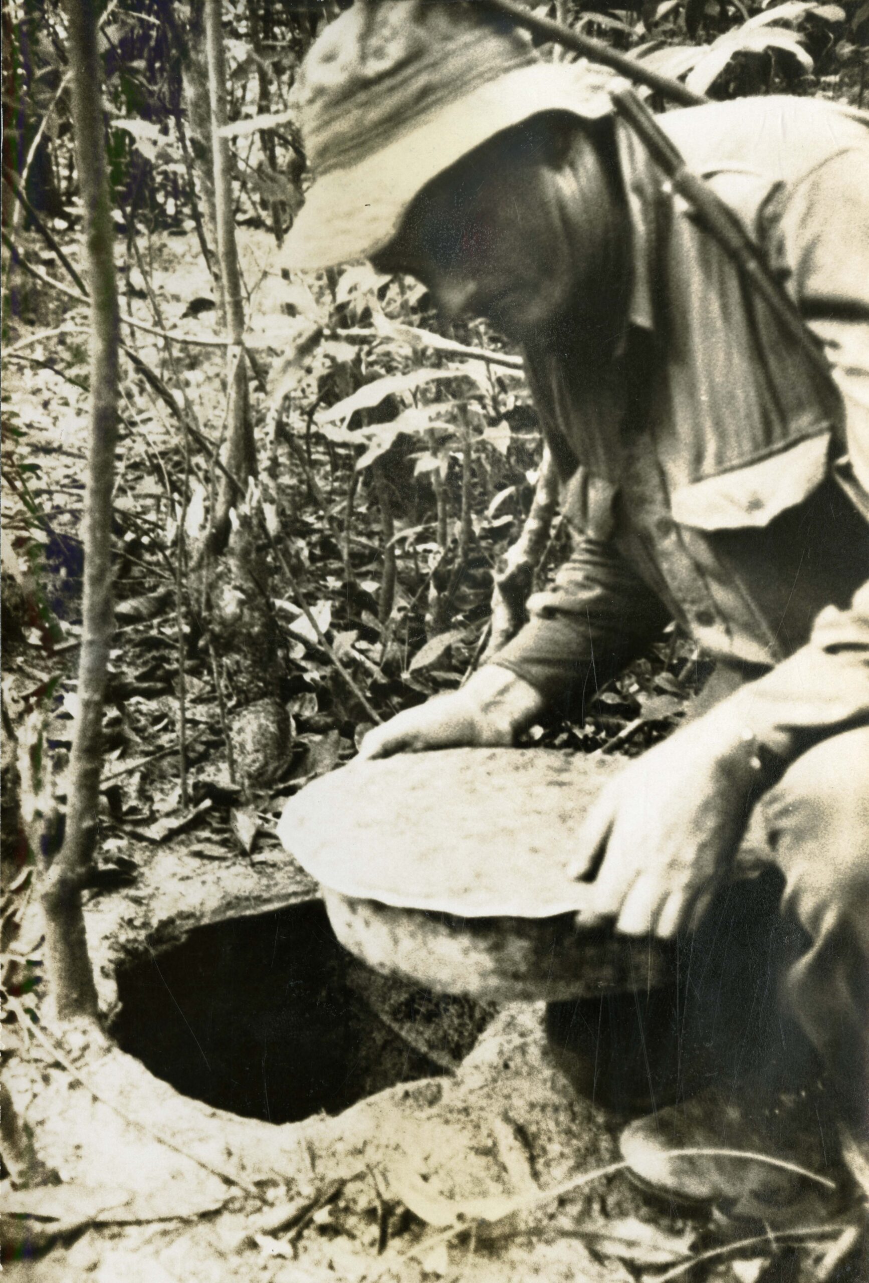 Royal Australian platoon sergeant removes Viet Cong tunnel cover, undated