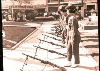 Several Vietnamese women are standing in line behind their guns