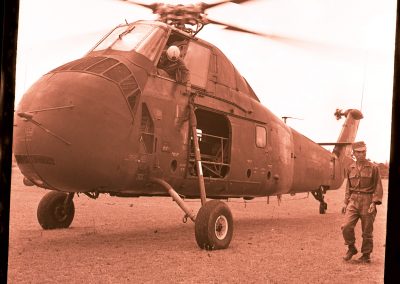 A young Vietnamese soldier is walking next to a helicopter