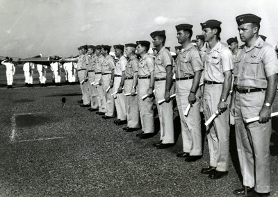 Twenty seven USAF pilots received Vietnamese Air Force wings and certificates of honorary membership in the VNAF at the ceremony at Tan Son Nhut Air Base, Saigon, on 12 March 1963. All were members of a group of 30 Air Force flyers assigned about a year ago to the 43rd VNAF Transport Groupto augment the shortage of Vietnamese pilots. The Air Force contingent use nicknamed the "Dirty Thirtys" from the outset. Twenty pilots, shown here, were present for the decorations, seven were absent. All have completed between 600 and 700 combat and airlift support missions in the role of co-pilot advisors and instructor pilots in Vietnamese. VNAF officier and airmen personnel stood at attention while Colonel Huyen Huu Hfen, VNAF Commader in Chief made the presentation.