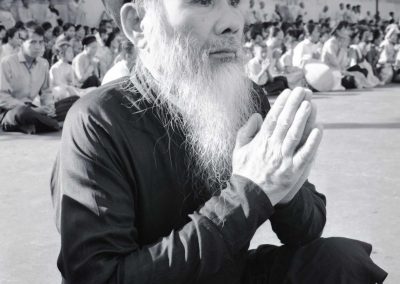 A man is seen in prayer as his photo is taken